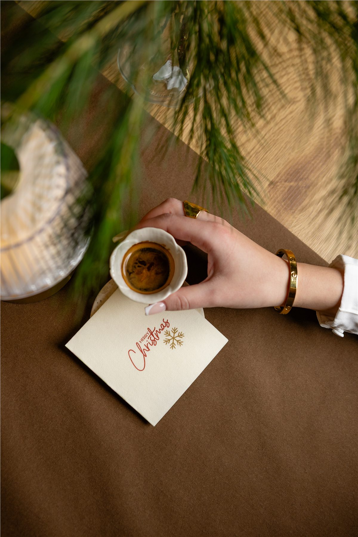 Overhead of a Merry Christmas printed napkin with a coffee cup