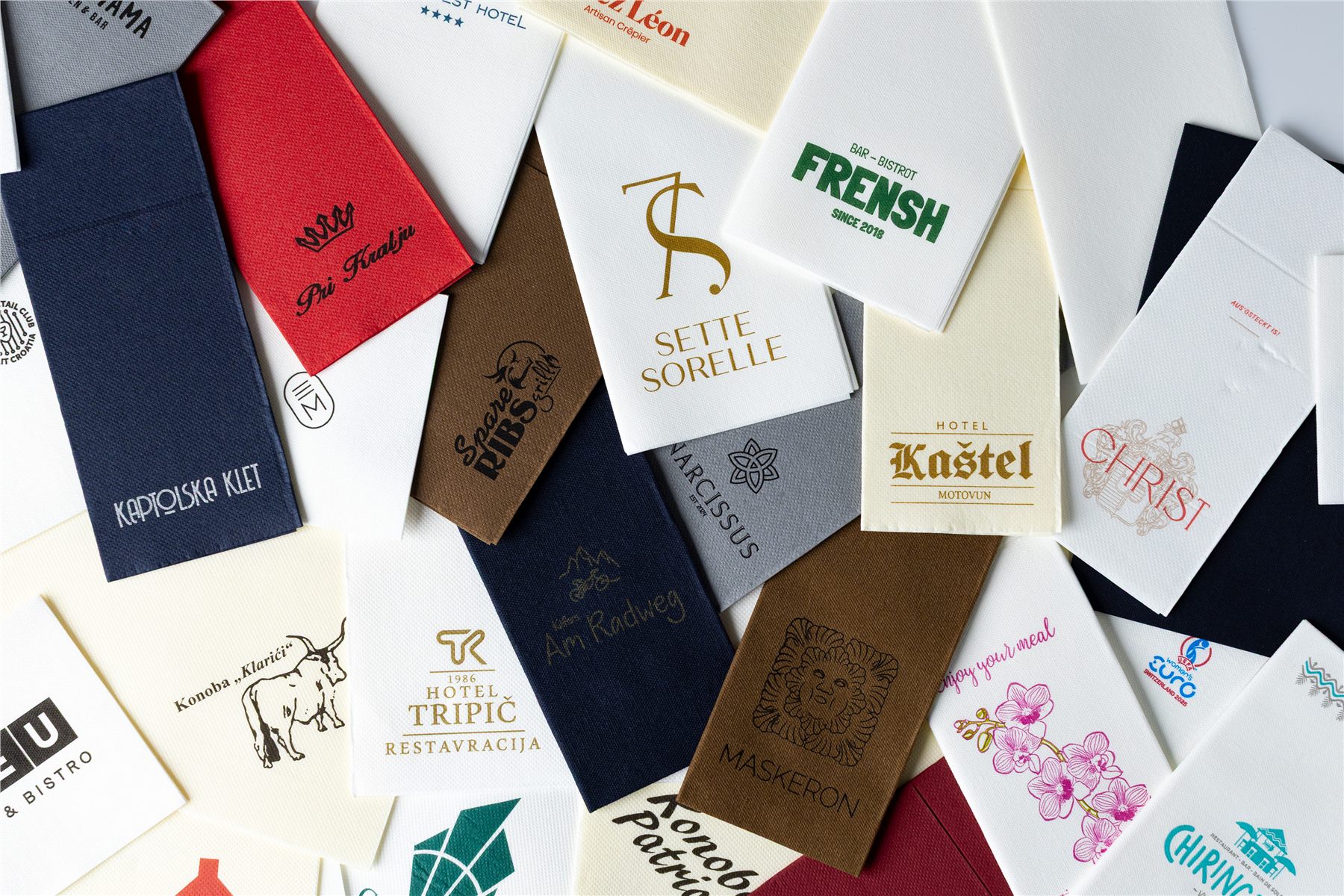 Overhead spread of napkins printed with various client logos